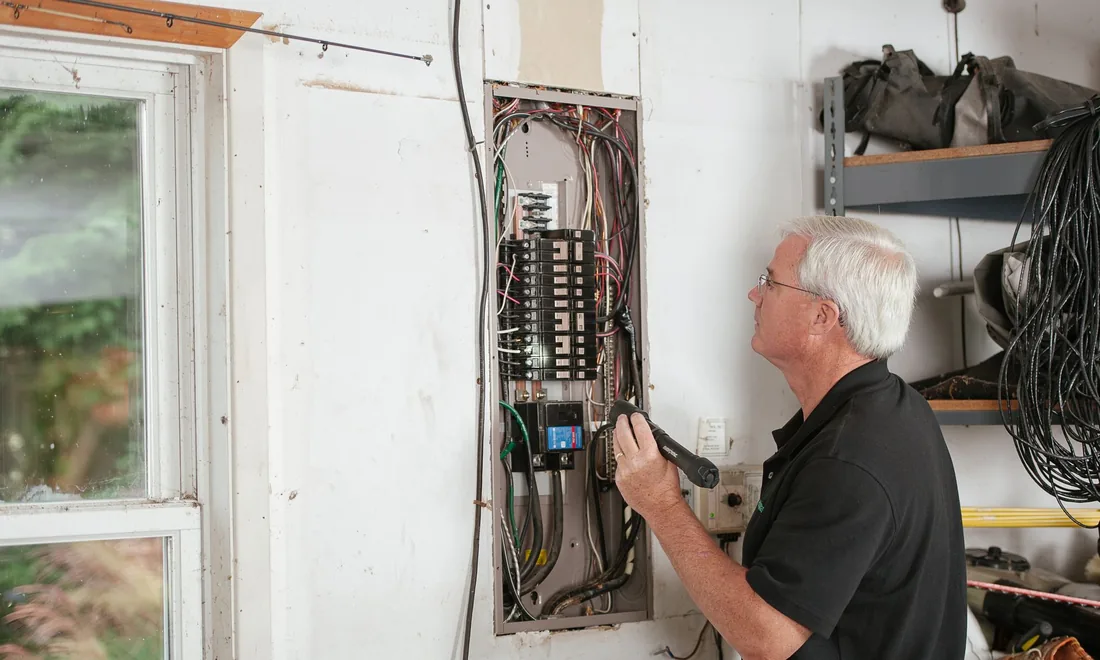 Elektrofachkraft arbeitet an einem Sicherungskasten in einem Wohngebäude